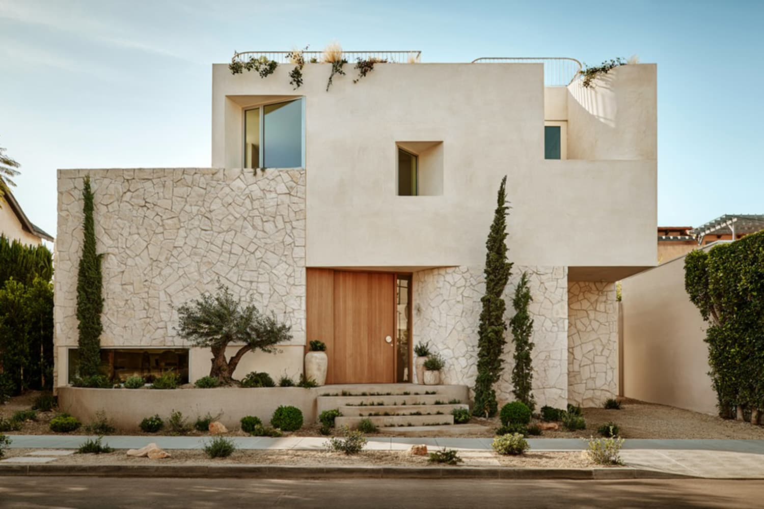 witness locations waring residence west hollywood los angeles exterior white stone facade cypress olive