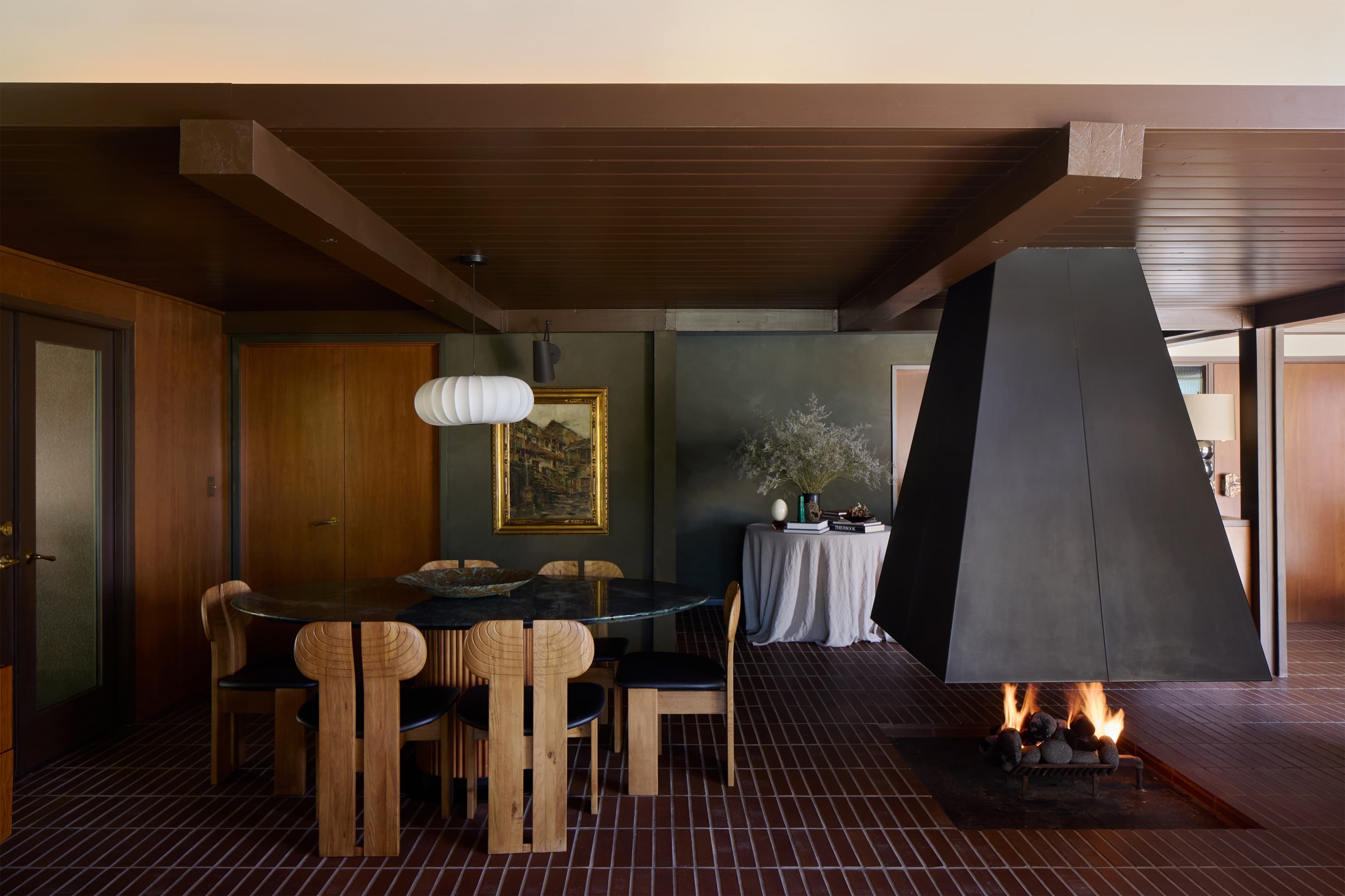 witness locations ember house woodland hills dining room suspended steel fireplace carved wood chairs brick floor