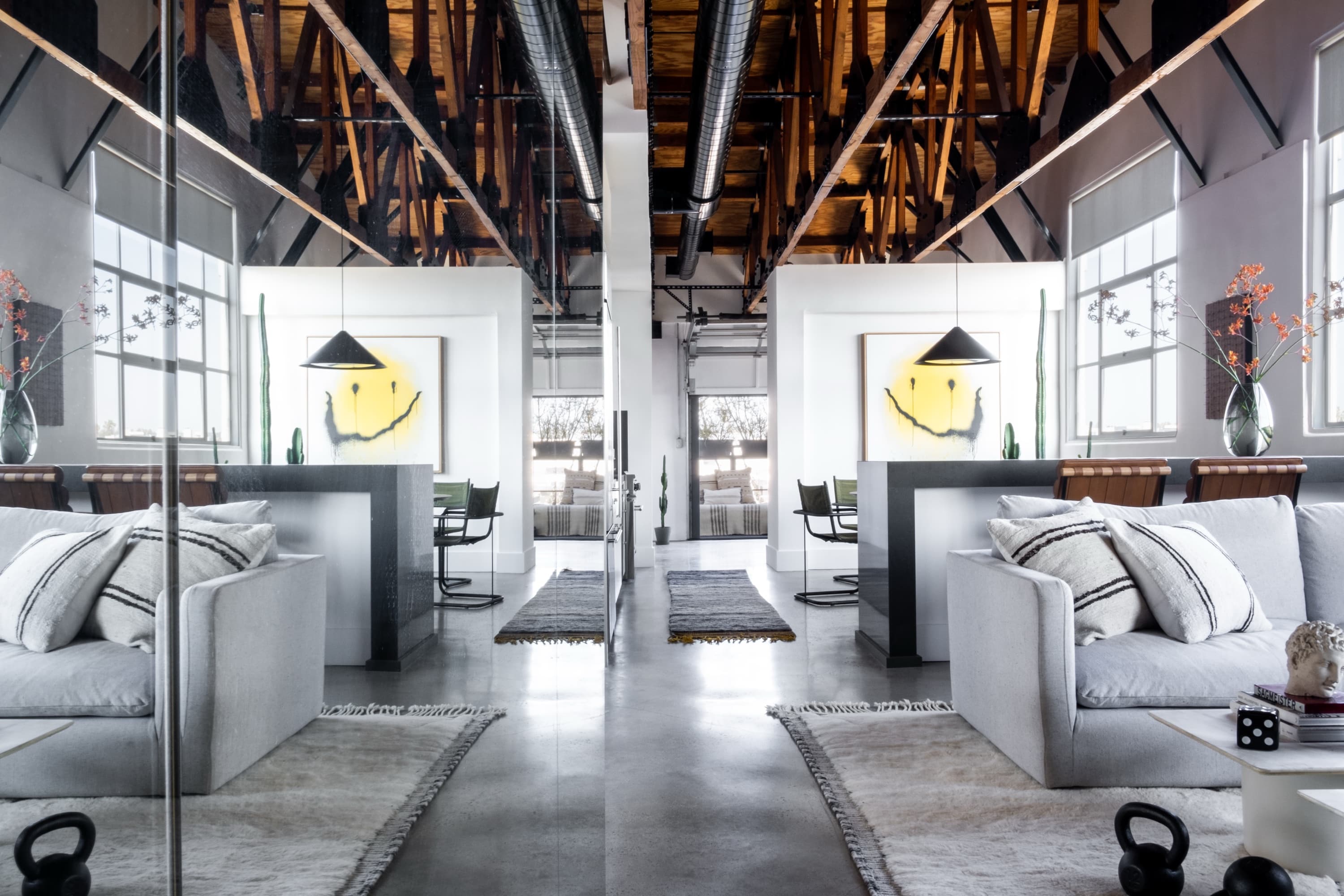 witness locations melrose place loft west hollywood los angeles living room exposed trusses sofas smiley artwork
