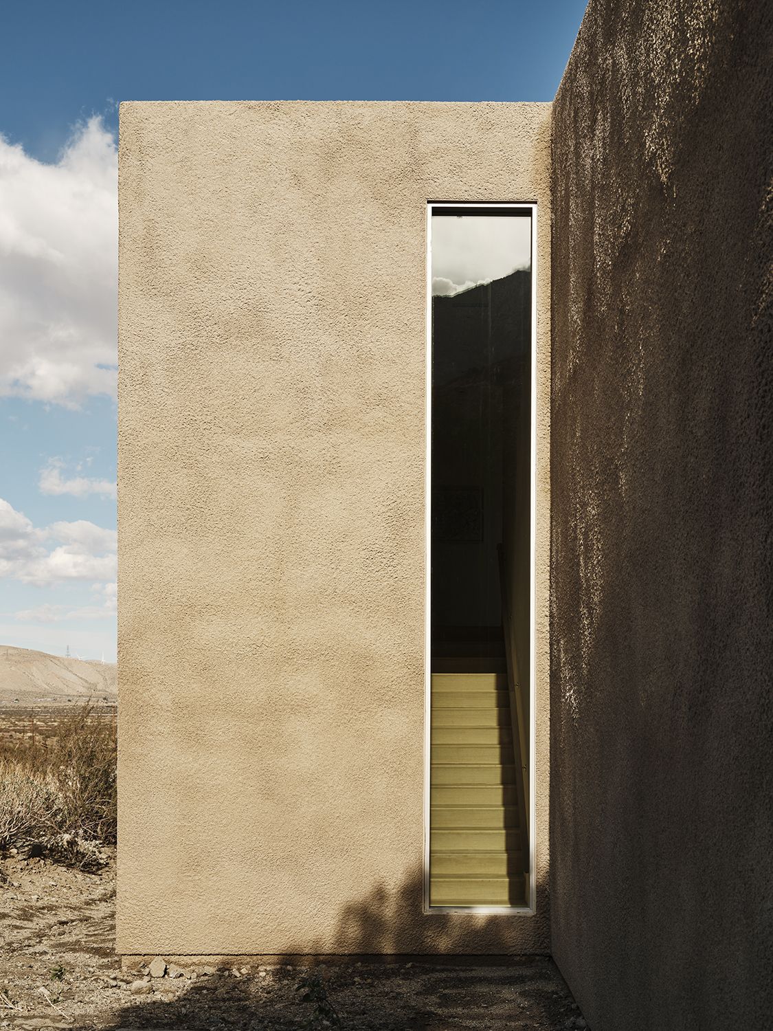 Plaster volume cut by a narrow stair slot at Windblock House, Palm Springs