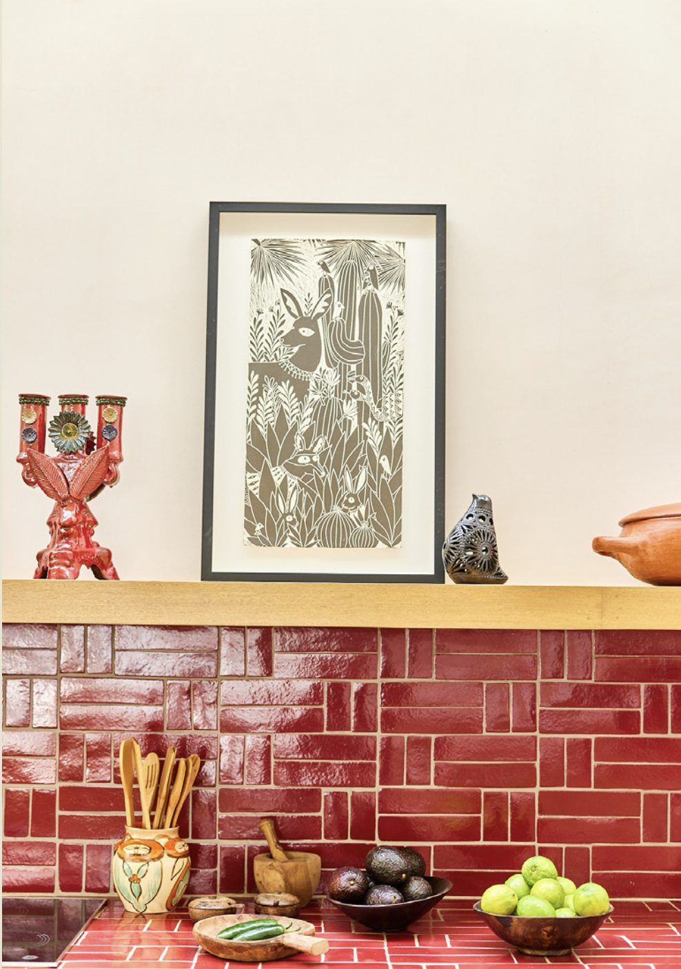 Red tile backsplash, a folk-art candelabra and a framed print in the kitchen at Rancho Cuatro Patas, Baja
