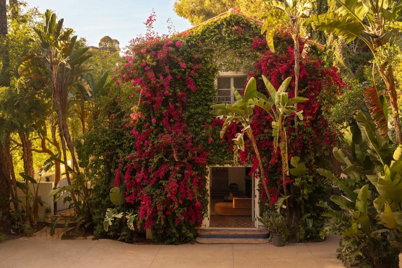 Mediterranean-style home framed by palms, agaves, and tropical landscaping in Beachwood Canyon