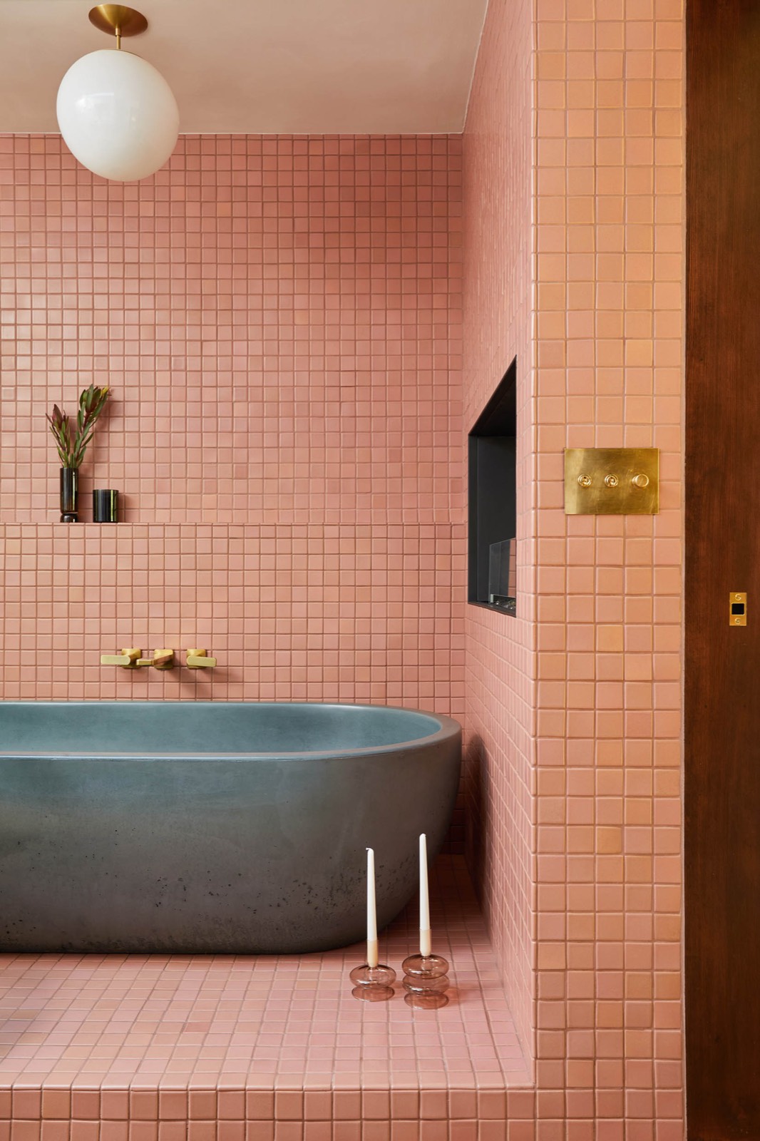 Pink-tiled bathroom with a sculptural tub at Merck House