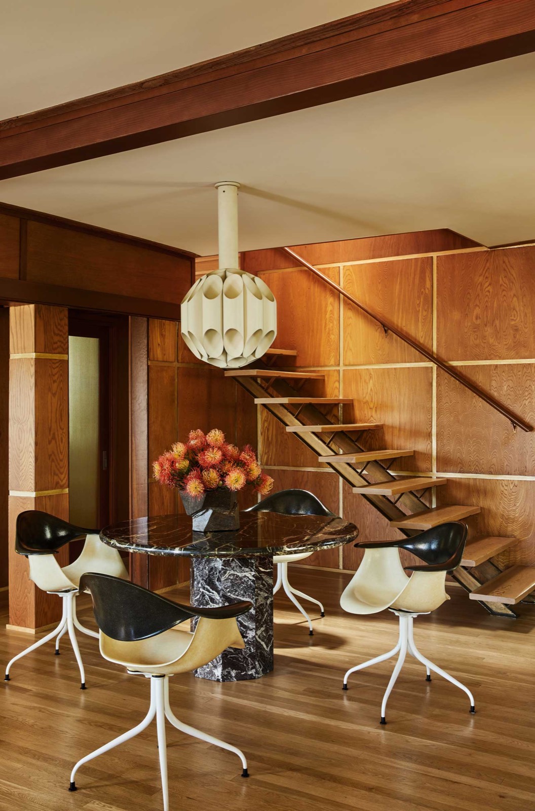 Dining room under a floating timber stair at Milano House, Silver Lake