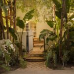 Spanish villa façade with white stucco, terracotta roof, and cascading bougainvillea.