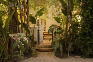 Spanish villa façade with white stucco, terracotta roof, and cascading bougainvillea.